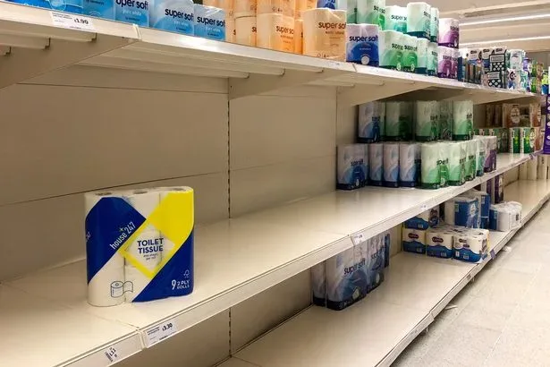 Пустые стеллажи и оставшиеся упаковки туалетной бумаги Кембридж